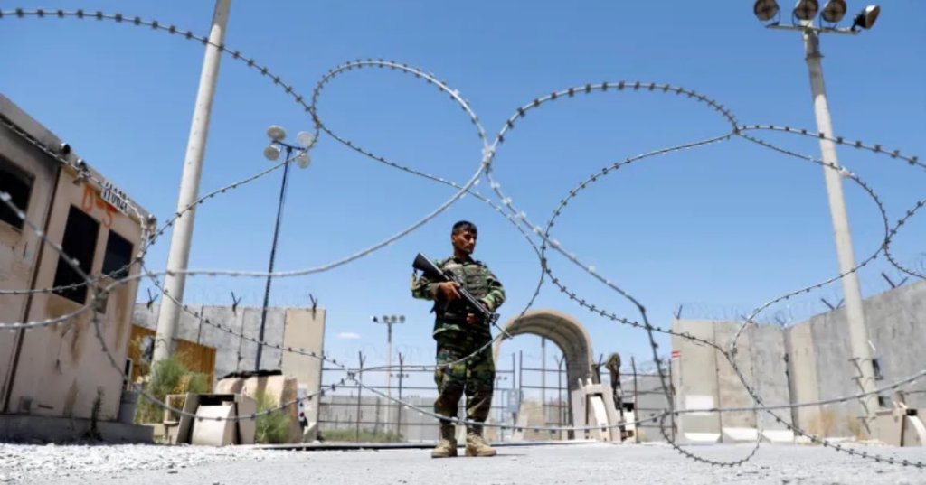 An Afghan soldier stands guard at the gate of Bagram US airbase in Parwan province on the day the last of American troops vacated it, July 2, 2021 [Mohammad Ismail/Reuters]