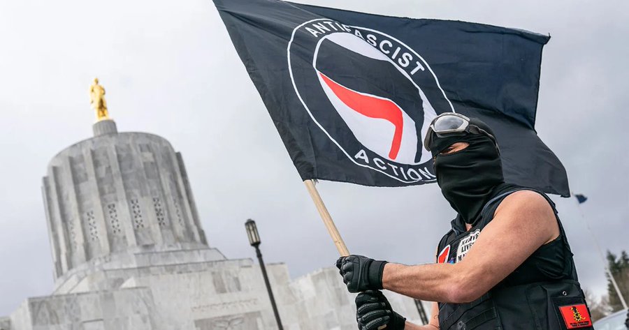 An Antifa protester waving an anti-fascist flag at the Oregon statehouse in in Salem, Oregon, March 2021.