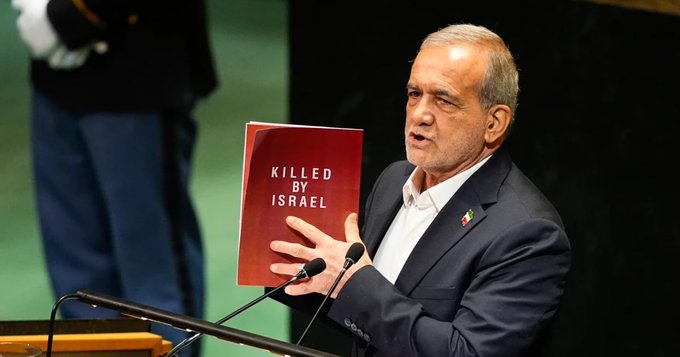 Iran President Masoud Pezeshkian holds up a book while speaking during the 80th session of the United Nations General Assembly, Wednesday, Sept. 24, 2025, at U.N. headquarters. (AP Photo/Yuki Iwamura)