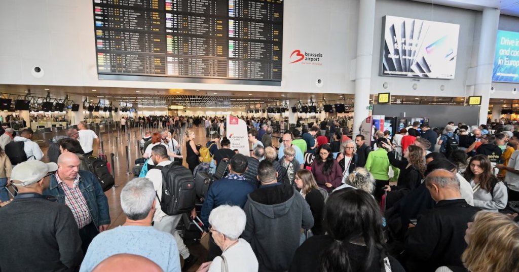 People stand in front of a departure board after a cyber attack caused delays at Brussels International Airport in Zaventem, Belgium, Saturday.