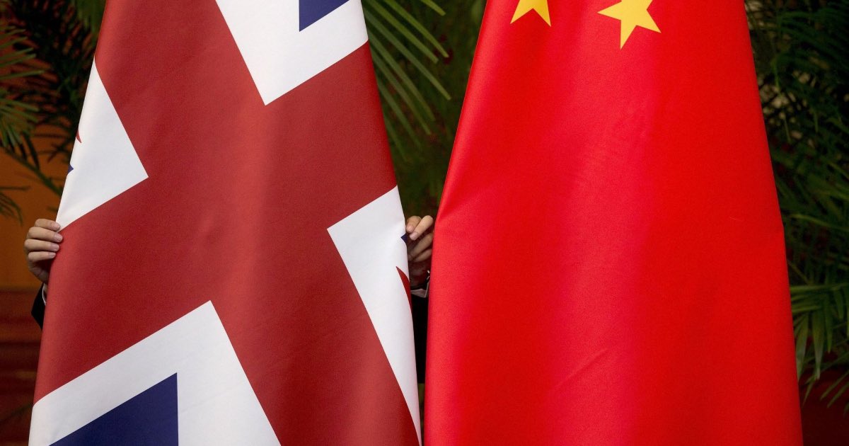 A worker adjusts British and China (R) national flags on display for a signing ceremony at the seventh UK-China Economic and Financial Dialogue "Roundtable on Public-Private Partnerships" at Diaoyutai State Guesthouse in Beijing, China September 21, 2015. REUTERS/Andy Wong