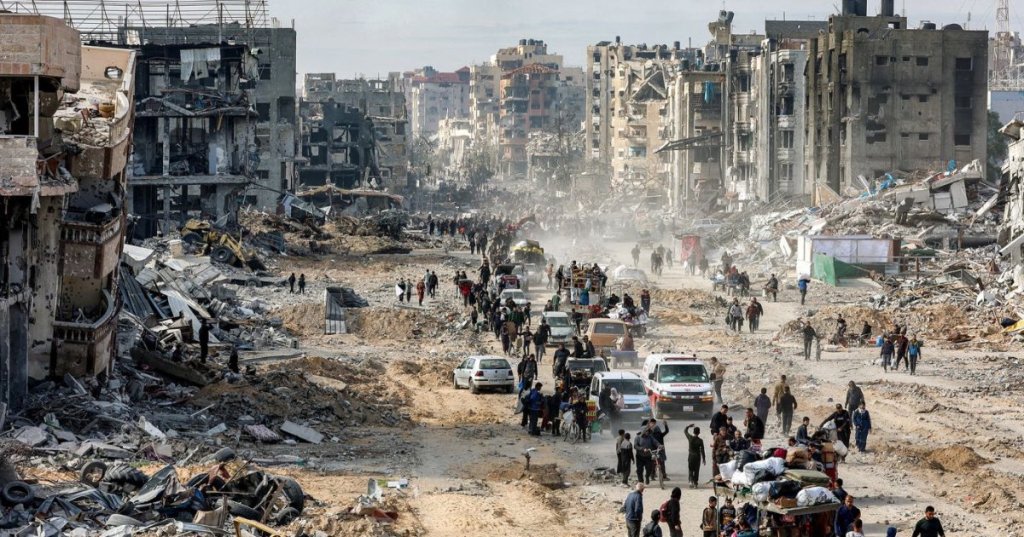 People walk past the rubble of collapsed buildings along Saftawi street in Jabalia in the northern Gaza Strip on January 20, 2025, a day after a short-lived ceasefire went into effect. Omar Al-Qattaa/AFP/Getty Images