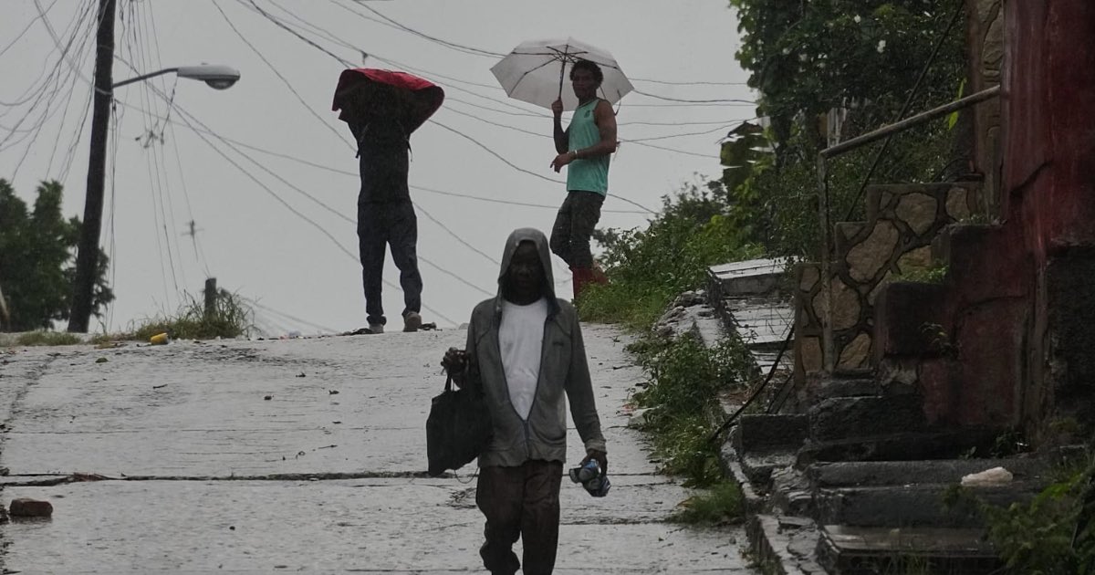 People walk under the rain before the arrival of Hurricane Melissa in Santiago de Cuba, Tuesday, Oct. 28, 2025. (AP Photo/Ramón Espinosa) - Copyright AP Photo