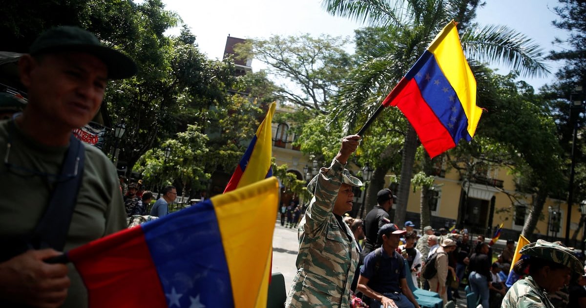 Members of the National Militia hold Venezuelan flags as they attend a military drill following Venezuelan President Nicolas Maduro's call to defend national sovereignty, amid rising tensions with the U.S., in Caracas, Venezuela October 4, 2025. REUTERS/Leonardo Fernandez Viloria/File Photo