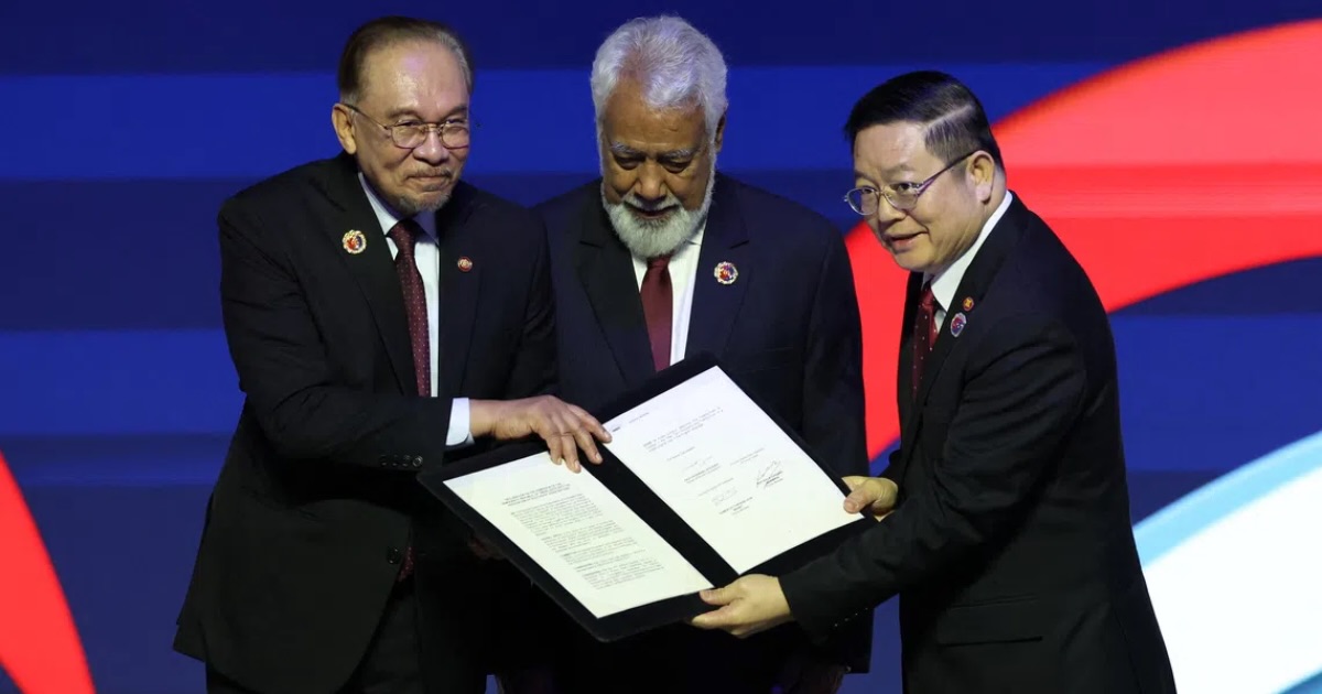 Malaysian Prime Minister Anwar Ibrahim (left) and Asean Secretary-General Kao Kim Hourn (right) with Timor-Leste’s Prime Minister Xanana Gusmao during the signing ceremony on Oct 26.PHOTO REUTERS