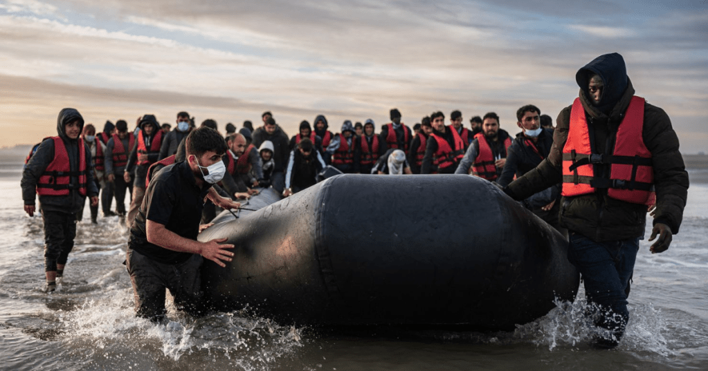Migrants move a smuggling boat into the water on the beach near Dunkirk, northern France as they prepare to cross the English Channel to the UK - Sameer Al-Doumy.AFP.Getty Images
