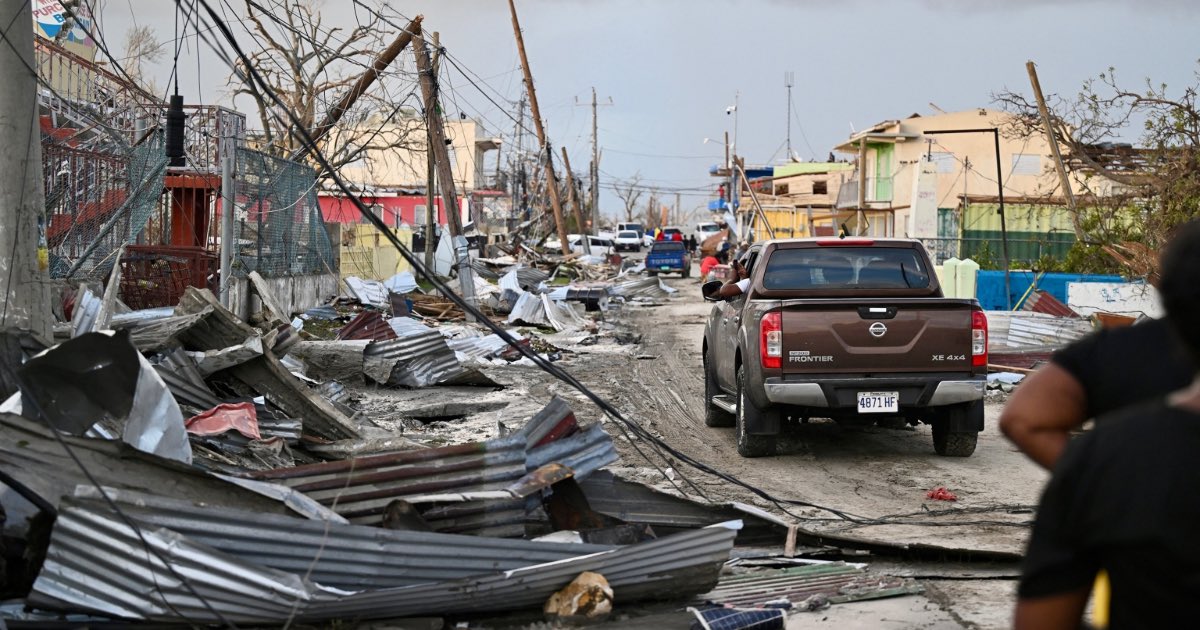 A car drives through the a destroyed neighborood following the passage of Hurricane Melissa, in Black River, Jamaica on October 29, 2025. Ricardo Makyn/AFP via Getty Images