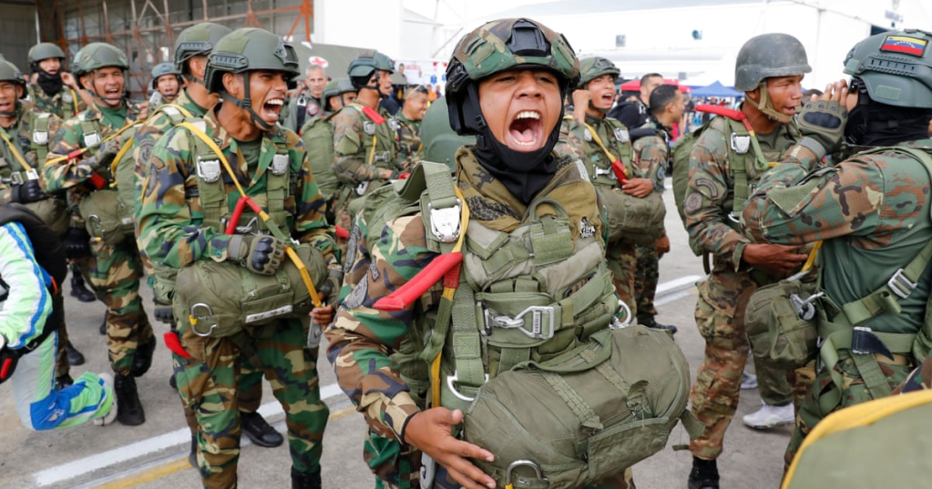 Skydivers get revved to perform in the Industrial Aviation Expo at the Libertador airbase in Maracay, Venezuela, on Saturday. Photograph: Cristian Hernandez/AP