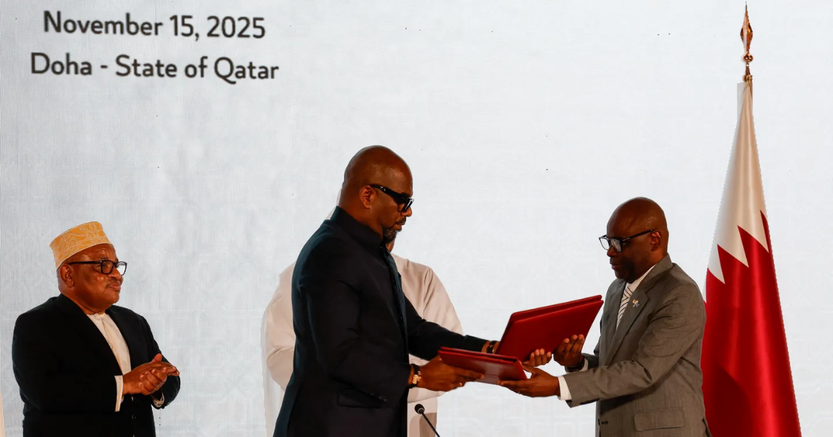 DR Congo's Sumbu Sita Mambu and head of the M23 delegation Benjamin Mbonimpa exchange documents at the ceremony in Doha, Qatar on November 15, 2025.