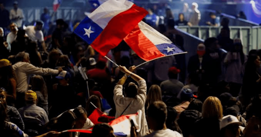 A supporter of Jose Antonio Kast, presidential candidate of the ‘far-right’ Republican Party, holds Chilean flags as they attend a closing campaign rally in Santiago, Chile November 11. Rodrigo Garrido/Reuters