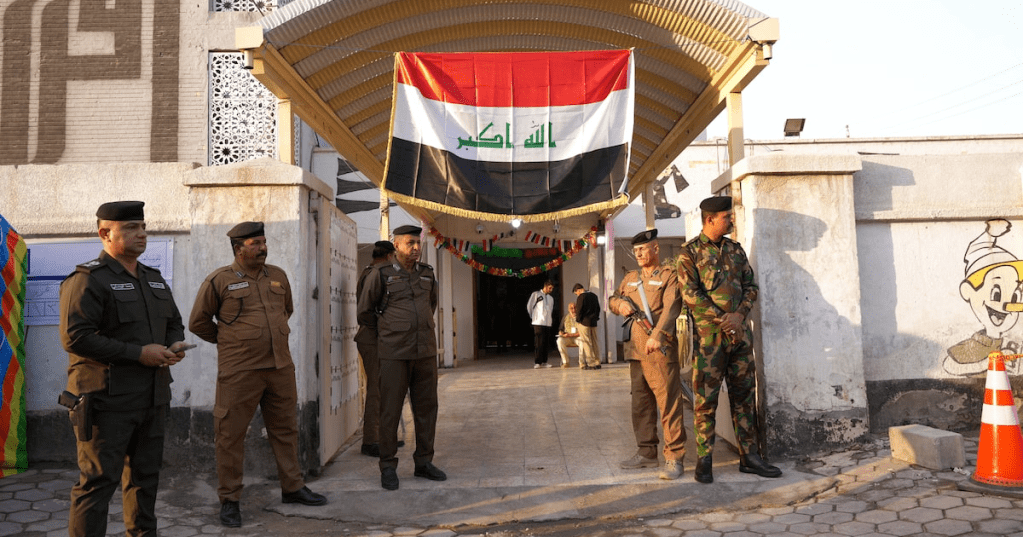 Security forces personnel stand guard outside a polling station during general voting for a parliamentary election, in Basra, Iraq, November 11, 2025. REUTERS/Essam Al-Sudani