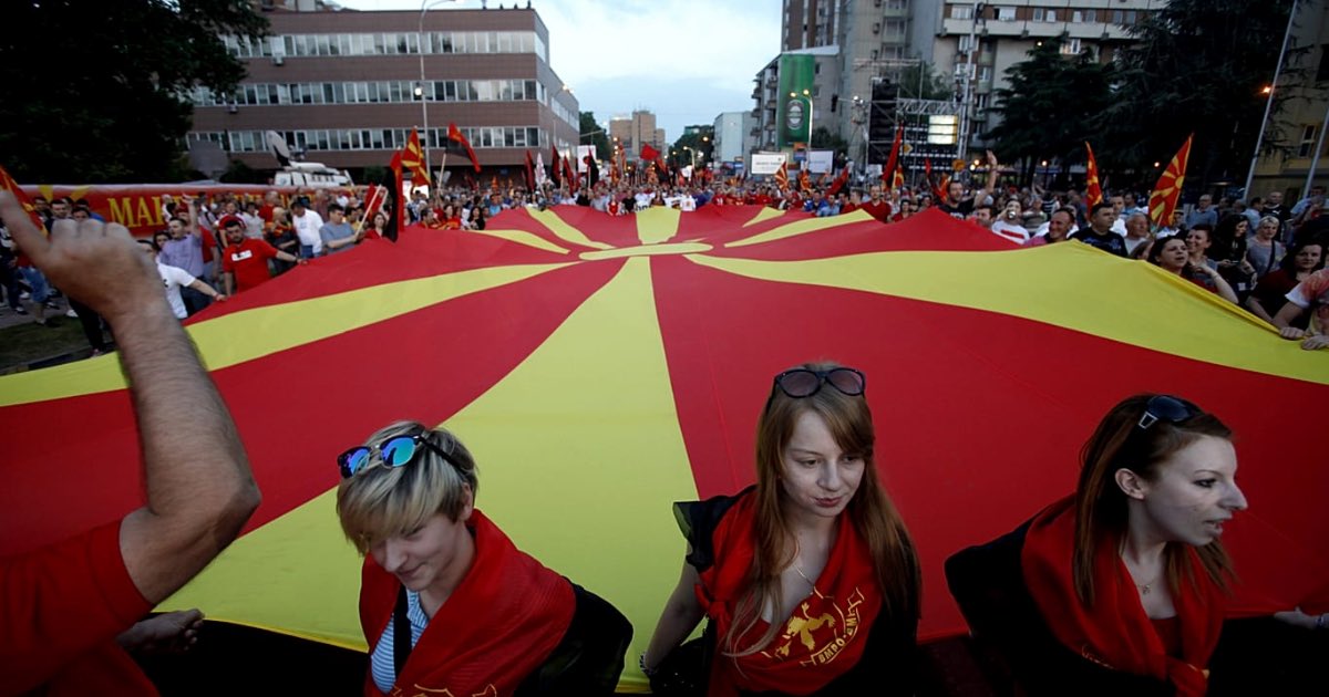 Supporters of the ruling coalition wave national and party flags, during a rally in front of the Parliament building in Skopje, 18 May 2015 - Copyright AP Photo