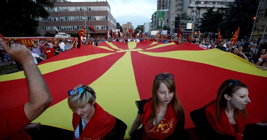 Supporters of the ruling coalition wave national and party flags, during a rally in front of the Parliament building in Skopje, 18 May 2015 - Copyright AP Photo