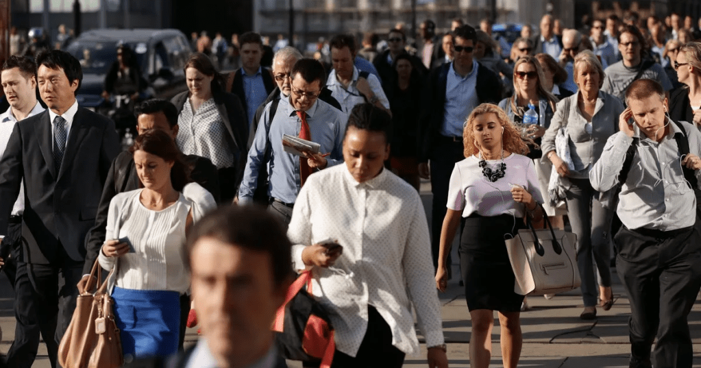 This image shows a crowd of commuters walking across London Bridge during a morning or evening rush hour. (PA)