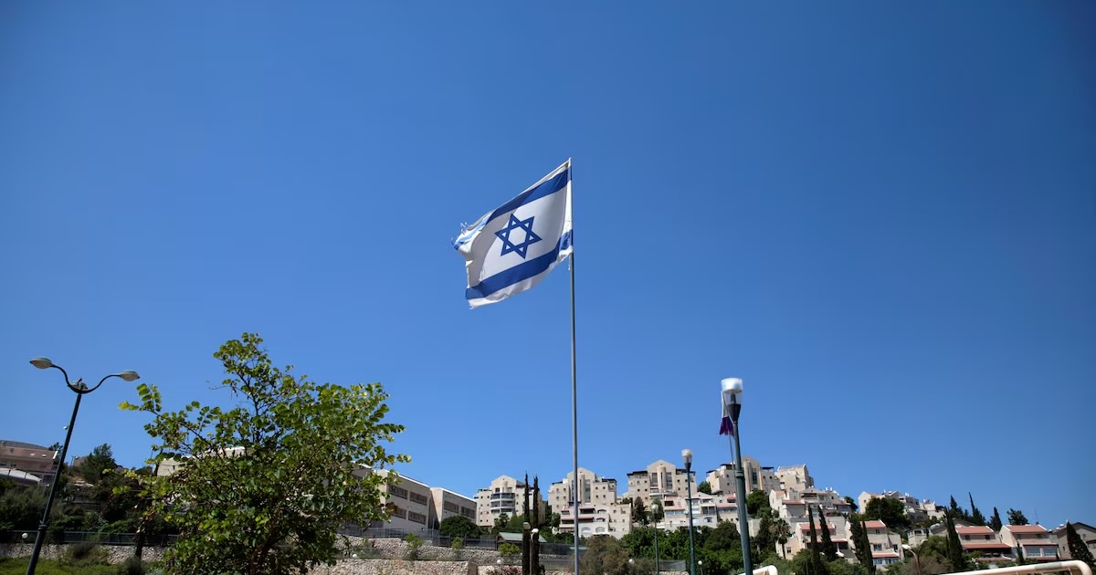 The Israeli national flag flutters as apartments are seen in the background in the Israeli settlement of Maale Adumim in the Israeli-occupied West Bank August 16, 2020. Picture taken August 16, 2020. REUTERS/Ronen Zvulun/File Photo