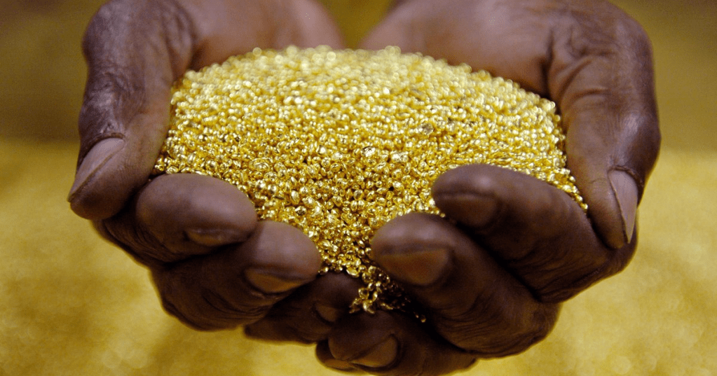The image shows hands holding a large quantity of gold granules or small gold nuggets. This type of raw gold is often recovered during mining operations (Photo credit.Bloomberg)