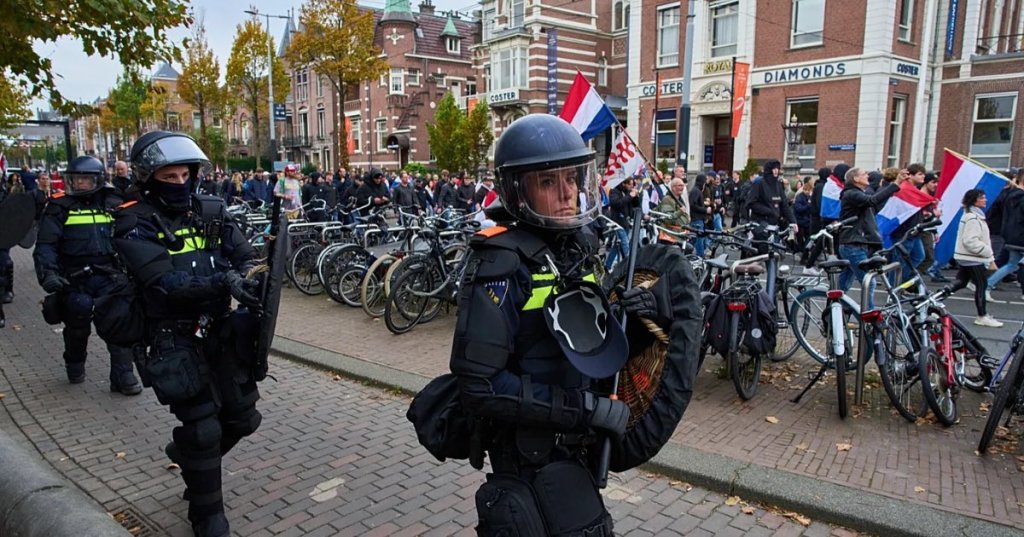 Dutch riot police escort anti-immigration protesters during a demonstration in Amsterdam, Netherlands, Sunday, Oct. 12, 2025. - Copyright AP Photo/Peter Dejong - tut0ugh via euronews