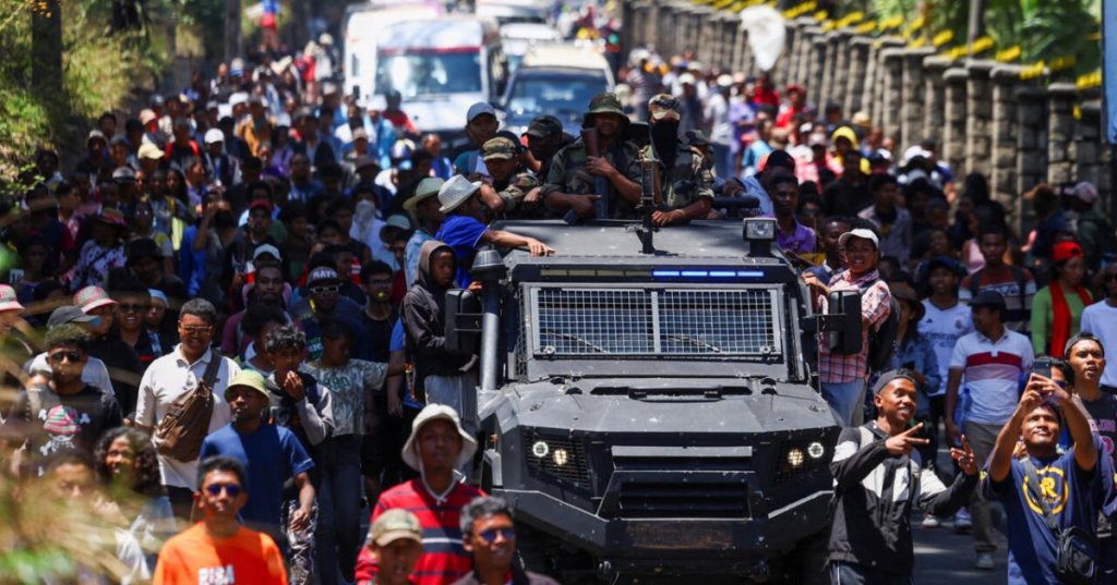 Protesters in Antananarivo, Madagascar, embrace a military vehicle, 13 October 2025. © Siphiwe Sibeko/Reuters